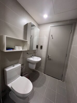 Une salle de bain moderne avec des toilettes, un lavabo et un miroir.