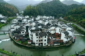 A riverside village with white buildings, a bridge, and a river.