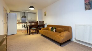 A compact living space with a kitchenette, a dining area, and a sofa. - Cosy 1 Bedroom Flat in Shadwell (London)