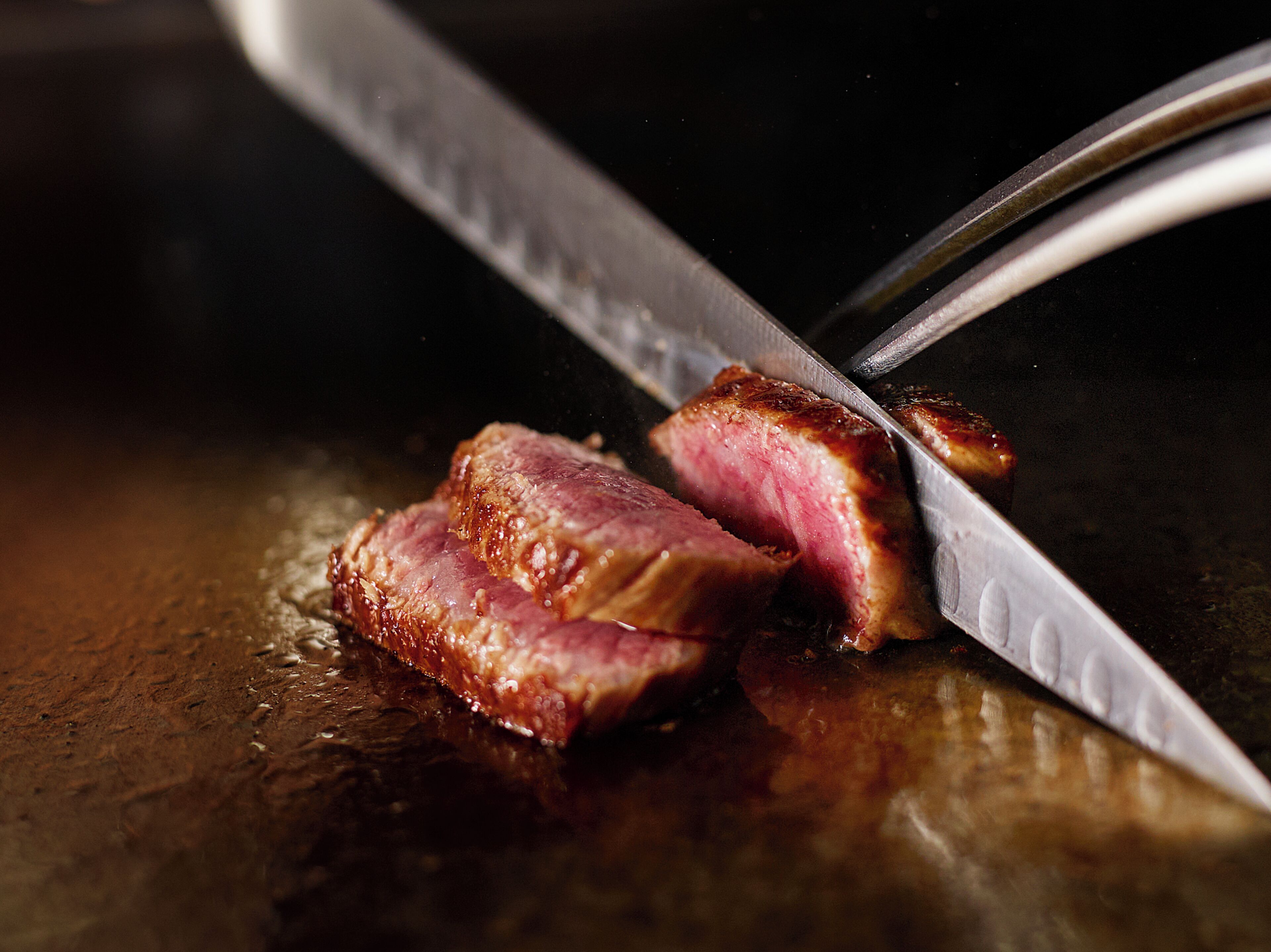 A steak being cut with a knife.