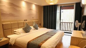 A hotel room with a large bed, a wooden headboard, a desk with a chair, and a balcony with curtains. - Yichun Jingfu Courtyard · Linmei Aishe Homestay (Yichun)