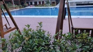 A pool area with a brick floor, surrounded by greenery and a wooden deck. - Yichun Jingfu Courtyard · Linmei Aishe Homestay (Yichun)