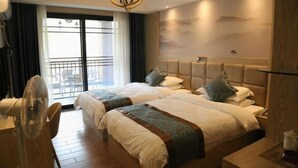 A hotel room with two beds, a fan, a desk, and a view of the outdoors. - Yichun Jingfu Courtyard · Linmei Aishe Homestay (Yichun)
