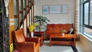 Un vestíbulo con muebles de madera, un ventanal grande y una pared decorada con cuadros.