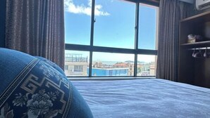 Una habitación con un ventanal grande, una cama y un armario.