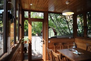 A wooden interior with a dining area, large windows, and a view of the outdoors. - Shenmi Sidou Hostel (Nanjing)