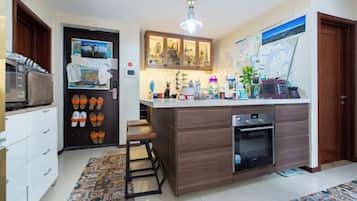 A compact kitchen with a central island, a microwave, and a refrigerator.