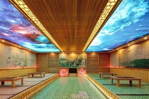 Quarto com teto representando um céu estrelado, bancos de madeira e piso verde.