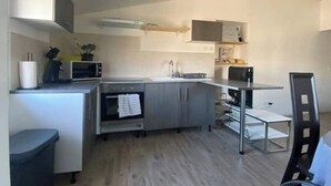 A compact kitchen with a microwave, oven, and sink. - T1 in Blaye (Blaye)