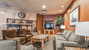 A living room with a fireplace, sofas, a coffee table, a television, and a clock on the wall. - Silver Mill 8220 (Keystone)