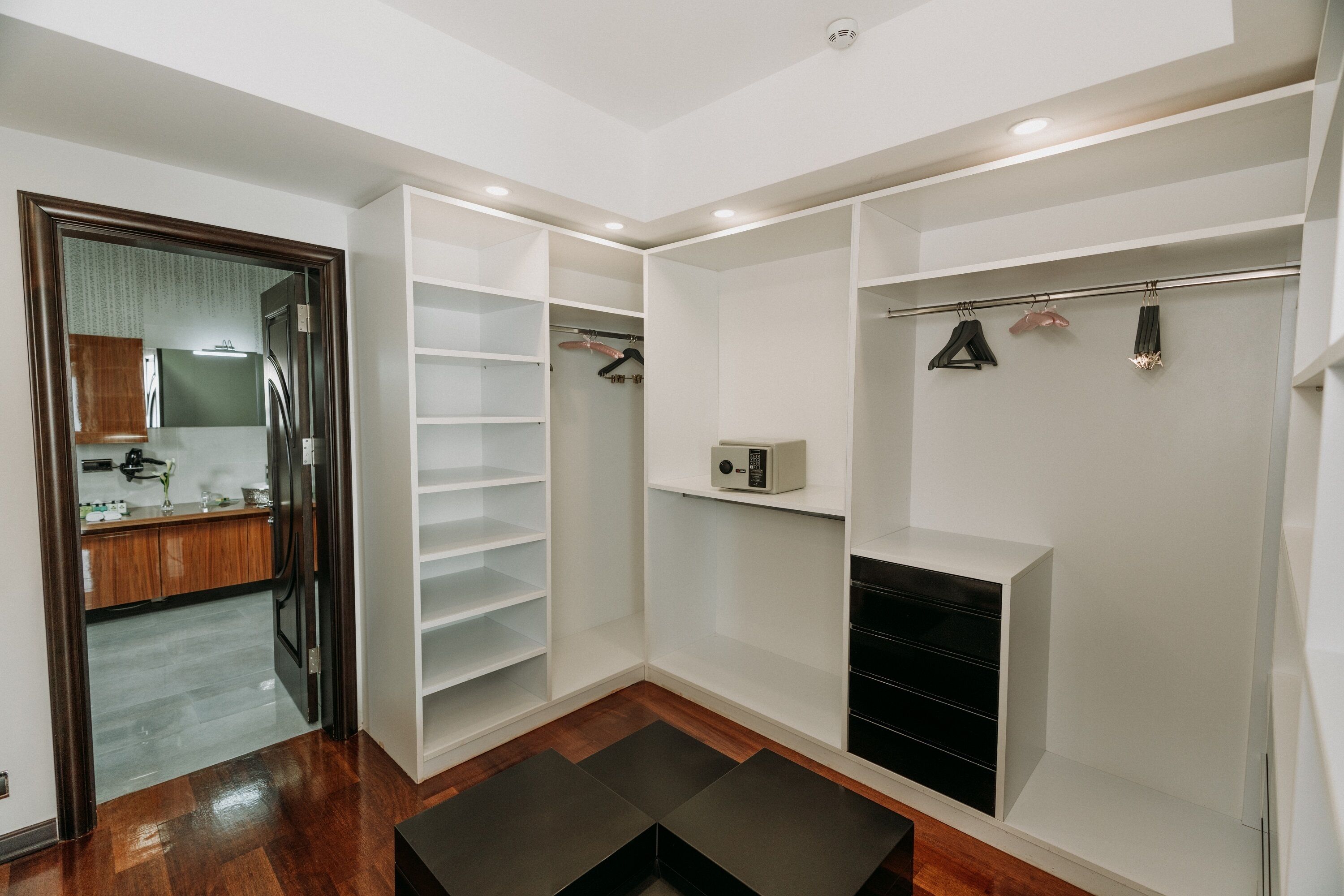 A walk-in closet with open shelving, a coat rack, and a small heater.