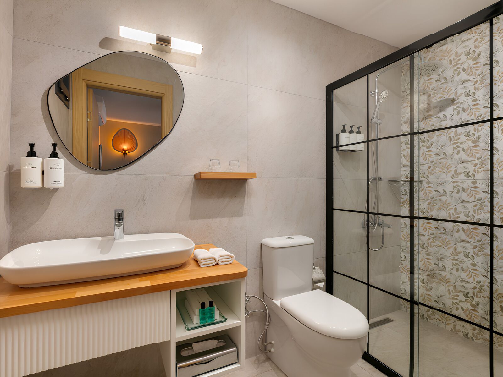 Ein modernes Badezimmer mit einem großem, ovalen Waschbecken, einer Toilette und einer Duschkabine.