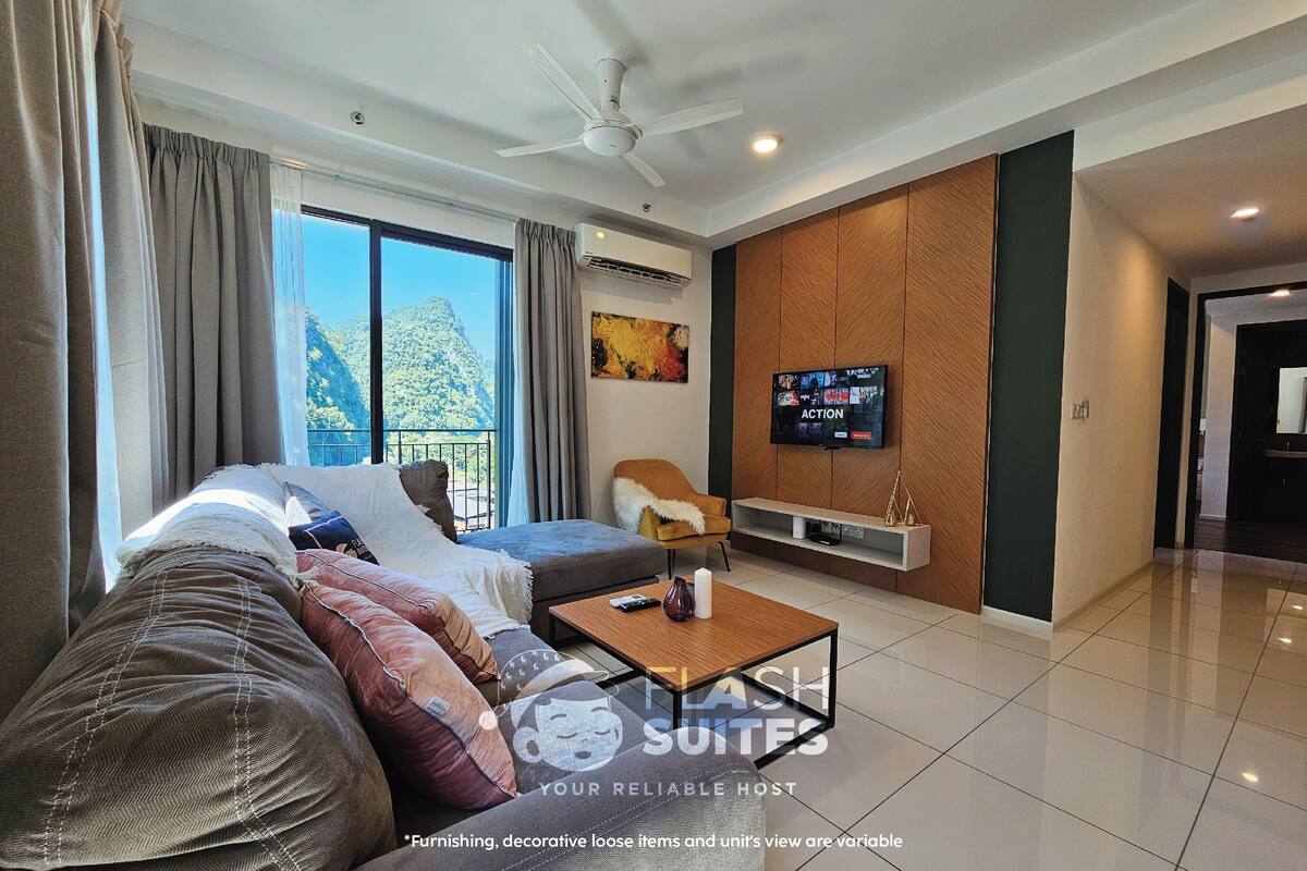 A modern living room with a sofa, a coffee table, a TV, and a view of a mountainous landscape.