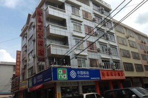 A multi-story building with commercial signage, including a mobile service provider and a restaurant. - Hezhou Huangyao Longquan Business Hotel (Zhaoping)