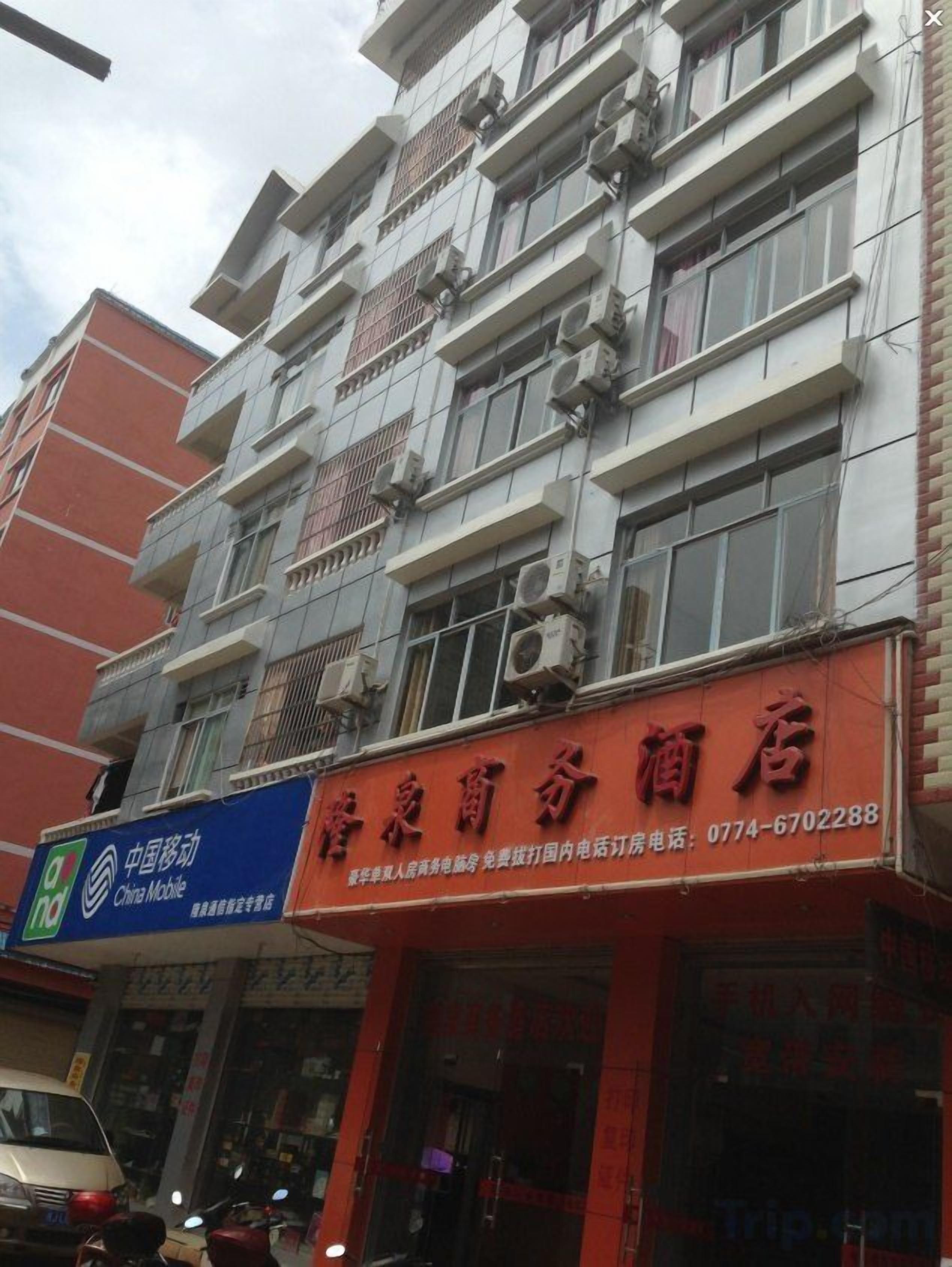 Un edificio de varios pisos con fachada roja y un letrero azul de China Mobile.