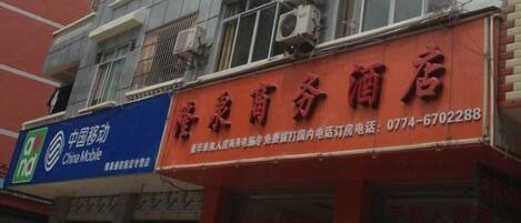 A multi-story building with a red storefront and a blue sign for China Mobile.