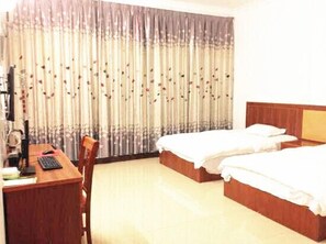 A hotel room with two beds, a desk, and a chair. - Hezhou Huangyao Longquan Business Hotel (Zhaoping)