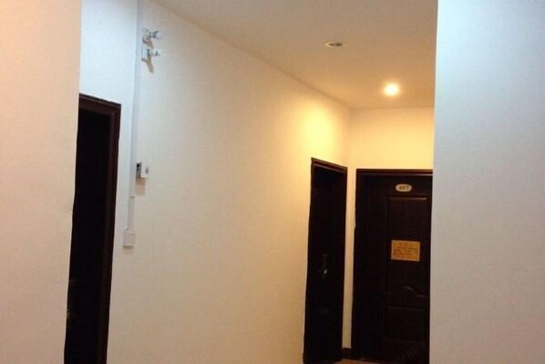 A narrow hallway with white walls and a door at the end. - Hezhou Huangyao Longquan Business Hotel (Zhaoping)