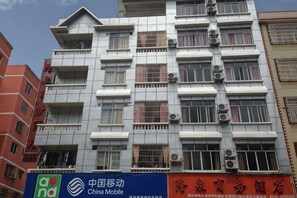 A multi-story building with a sign for China Mobile and another sign with Chinese characters. - Hezhou Huangyao Longquan Business Hotel (Zhaoping)