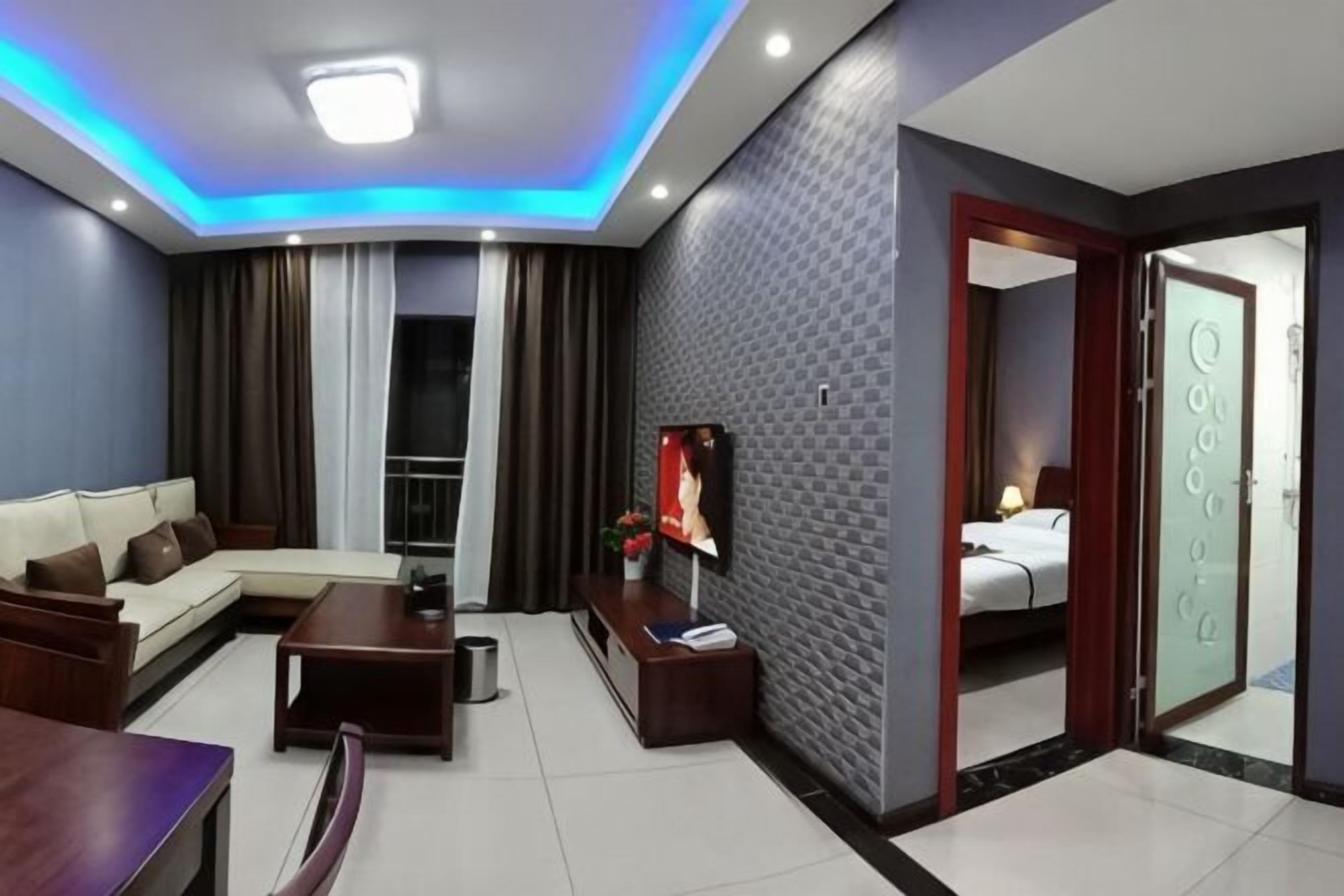 Habitación de hotel moderna con sofá, televisión y balcón.