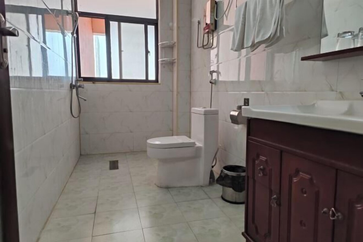 Un baño con inodoro, lavamanos y zona de ducha.