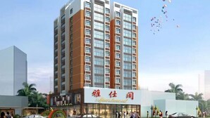 A multi-story hotel with a modern design, featuring a prominent sign with Chinese characters and a large glass facade. - Yashige Apartment Ruili (Ruili)