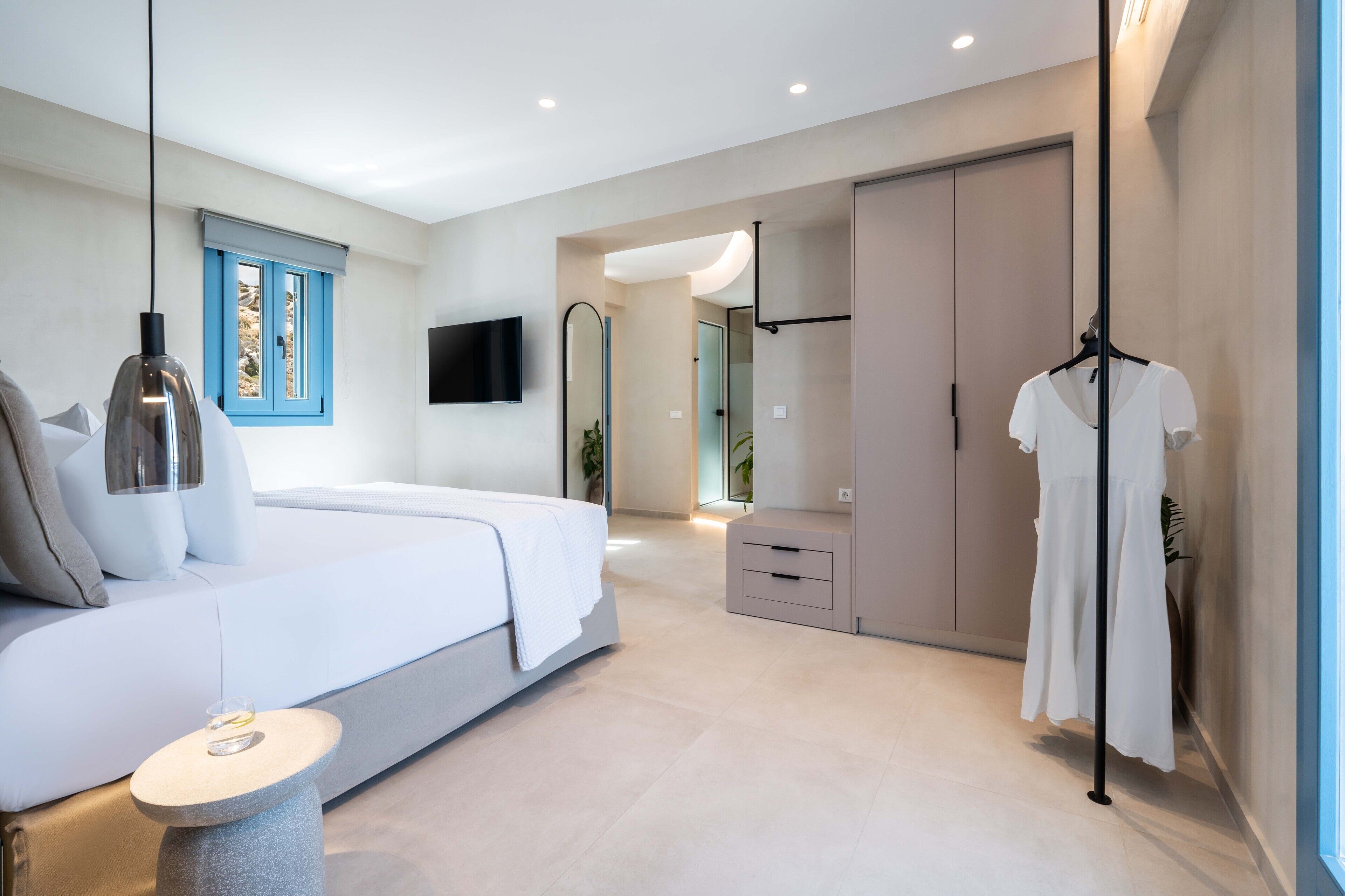 Een moderne slaapkamer met een bed, nachtkastje en hanglamp.