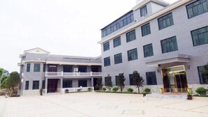 A multi-story hotel with a modern design, featuring a central courtyard and a prominent entrance with a glass door. - Jiayuan Holiday Hotel (Liuyang)