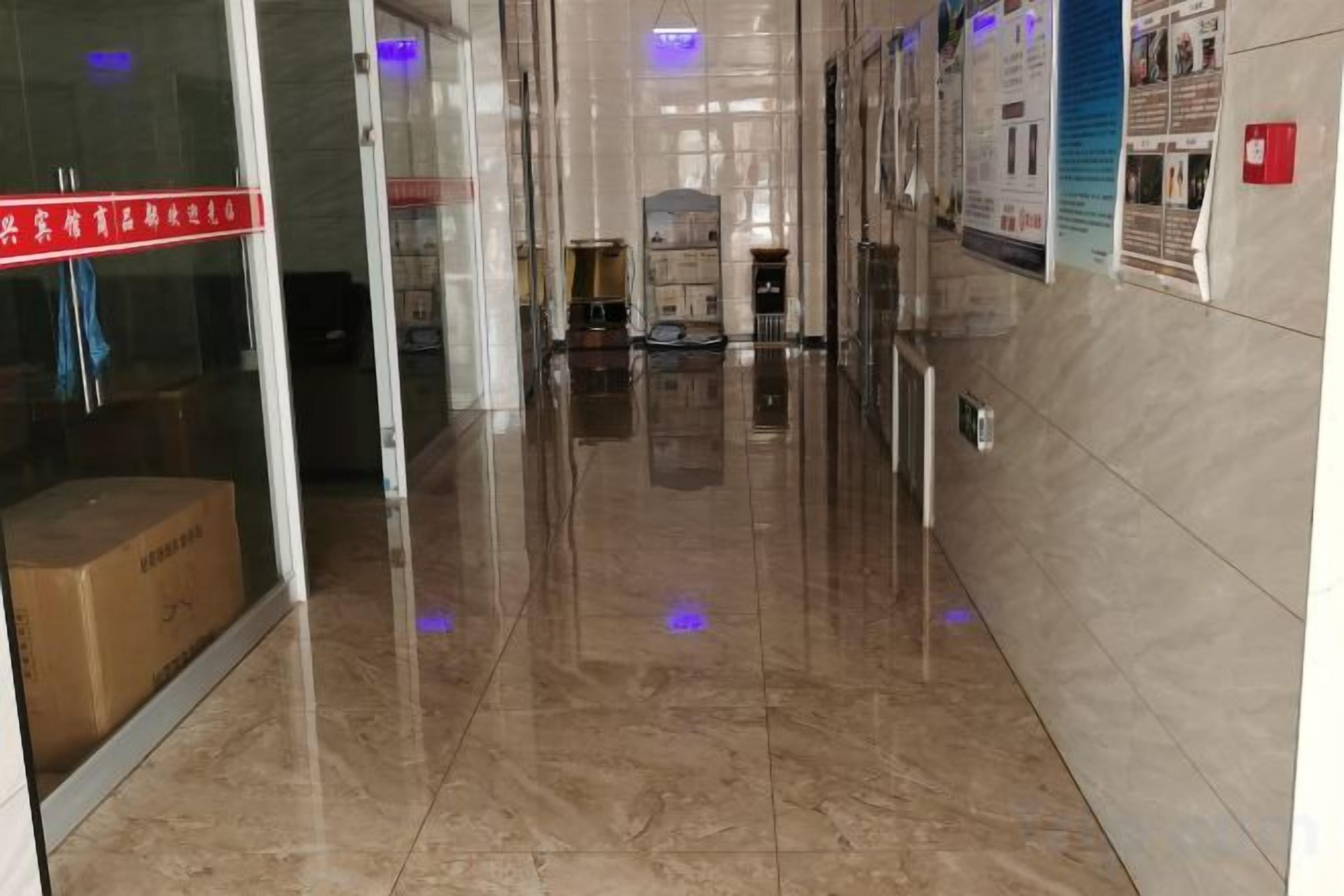 A hallway with a glass door, a cardboard box, and a poster on the wall.