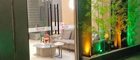 A modern interior with a sofa, coffee table, and decorative plants.