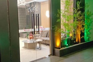 Een modern interieur met een bank, bijzettafeltje en decoratieve planten.