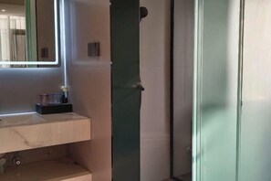 Une salle de bain avec un miroir, un lavabo et un espace douche.