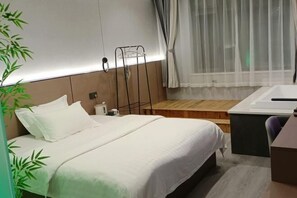 Une chambre d’hôtel avec un lit, une table de chevet et un petit bureau.