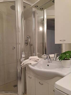 Chuveiro, secador de cabelo, bidê, toalhas de banho
