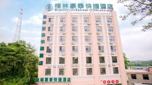 A multi-story hotel building with a uniform facade, multiple windows, and a visible entrance. - Shiniuzhai Pinru Villa (Pingjiang)