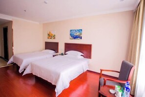 A hotel room with two beds, a wooden floor, a chair, and a painting on the wall. - Shiniuzhai Pinru Villa (Pingjiang)