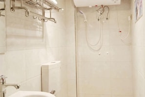 Une salle de bain avec un lavabo, un miroir et une douche.