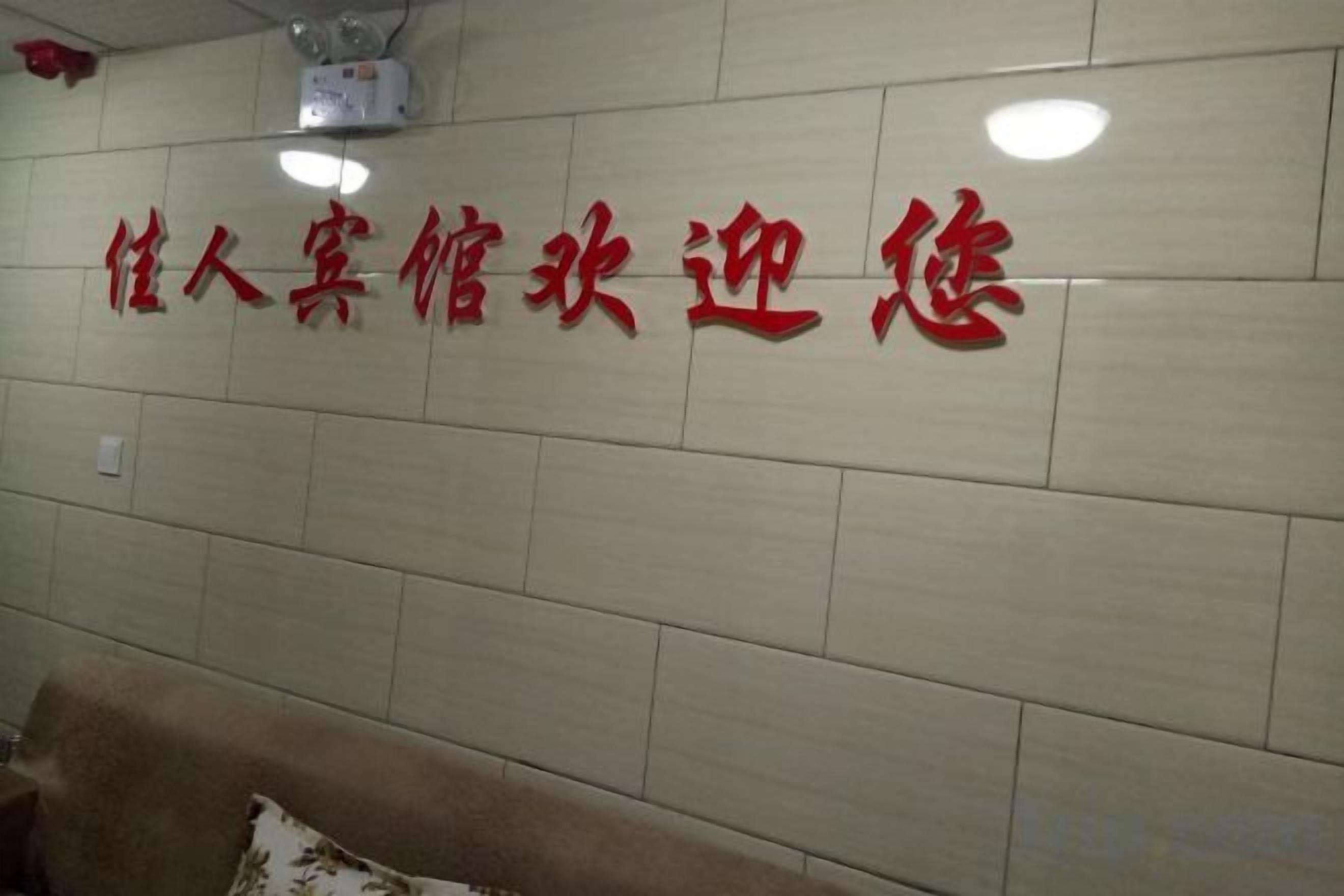 A wall with red text in a foreign language, possibly a hotel or establishment name.