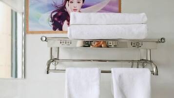 Un baño con un perchero que sostiene dos toallas blancas.