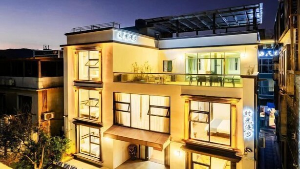 A modern multi-story building with large windows and a balcony. - Time Walk Guesthouse (Shenzhen)