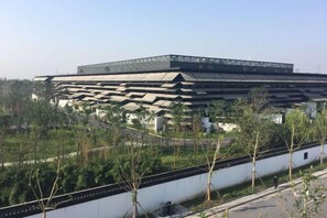 A large, multi-level building with a flat roof and a series of terraces. - Jinxiu Nianhua Inn (Tongxiang)