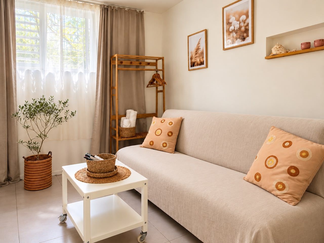 Un salón con sofá, una mesita, una planta y una estantería de madera con adornos.