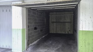 Garagem de estacionamento com paredes de concreto e teto de metal.