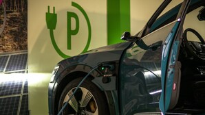 Un coche cargando en una estación con un símbolo verde 'P' en la pared.