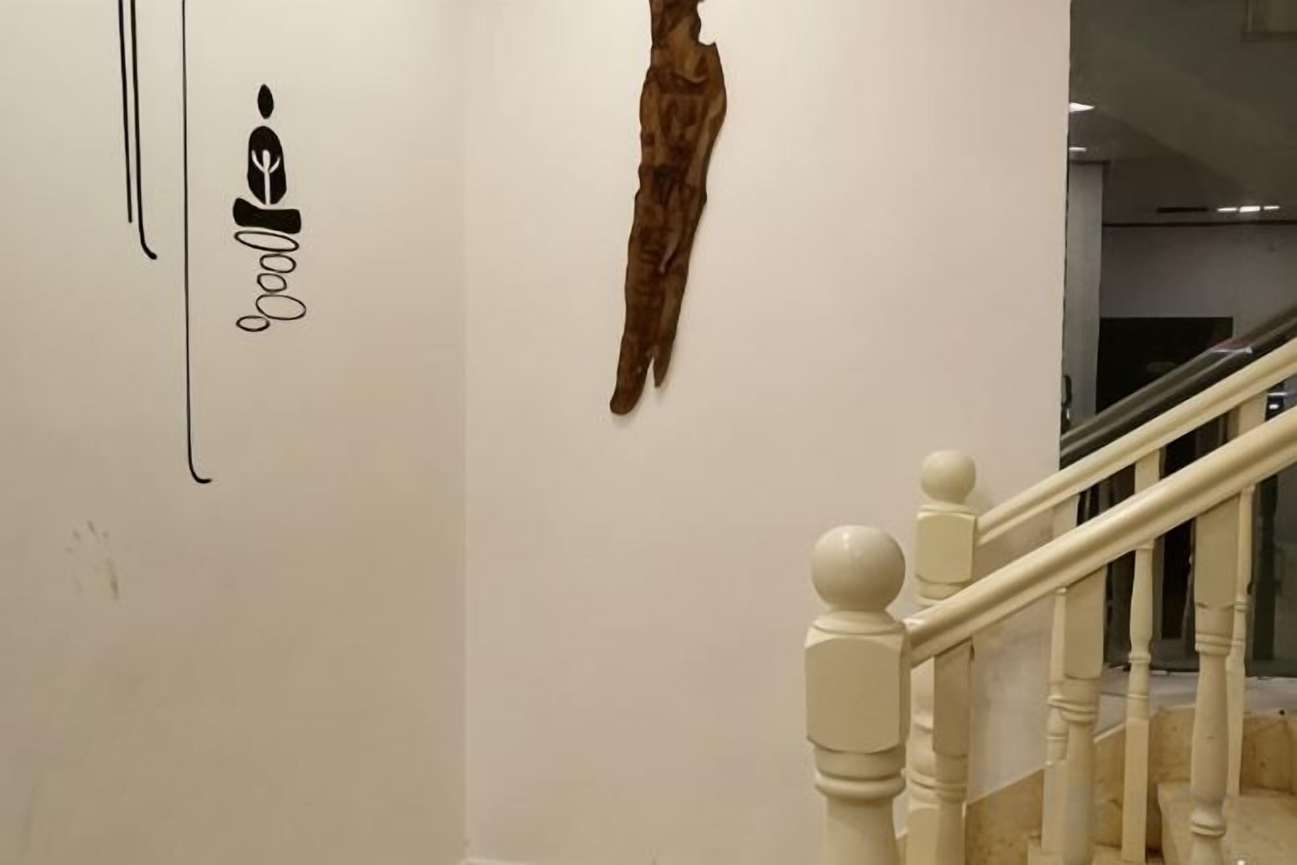 A staircase with white balusters and a wall with a mounted animal skin and a partial word 'goal'.