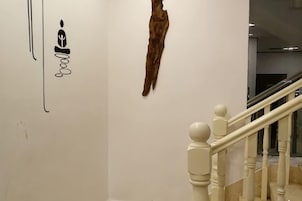 Una escalera con barandillas blancas y una pared con piel de animal colgada, mostrando la palabra 'goal' a medio escribir.