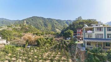 Una zona residencial con una colina, un edificio con balcones y un cielo despejado.