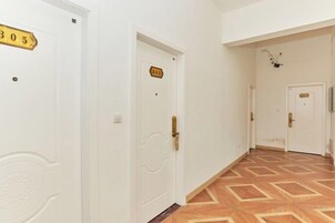 A hallway with white doors, each marked with a number.