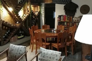 Un comedor con una mesa redonda y sillas, rodeado de estanterías y elementos decorativos.