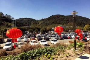 A parking lot with cars and red lanterns. - Xiangyue Villa Hotel (Pinghe)